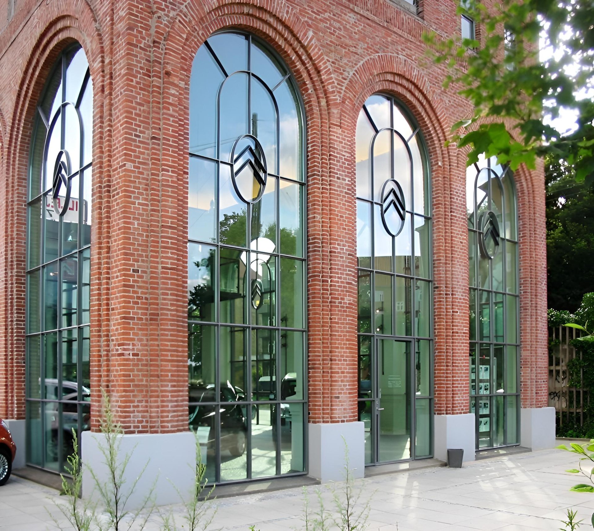 Hansen slim-profile steel-look aluminium arched windows in a red-brick building
