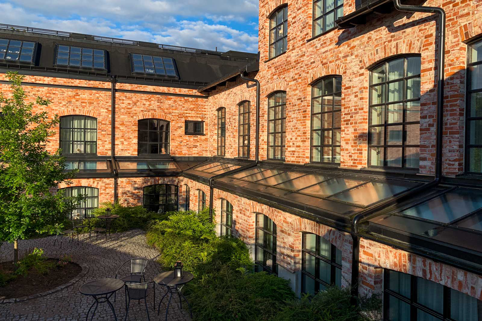 Steel-look aluminium windows around a landscaped heritage courtyard