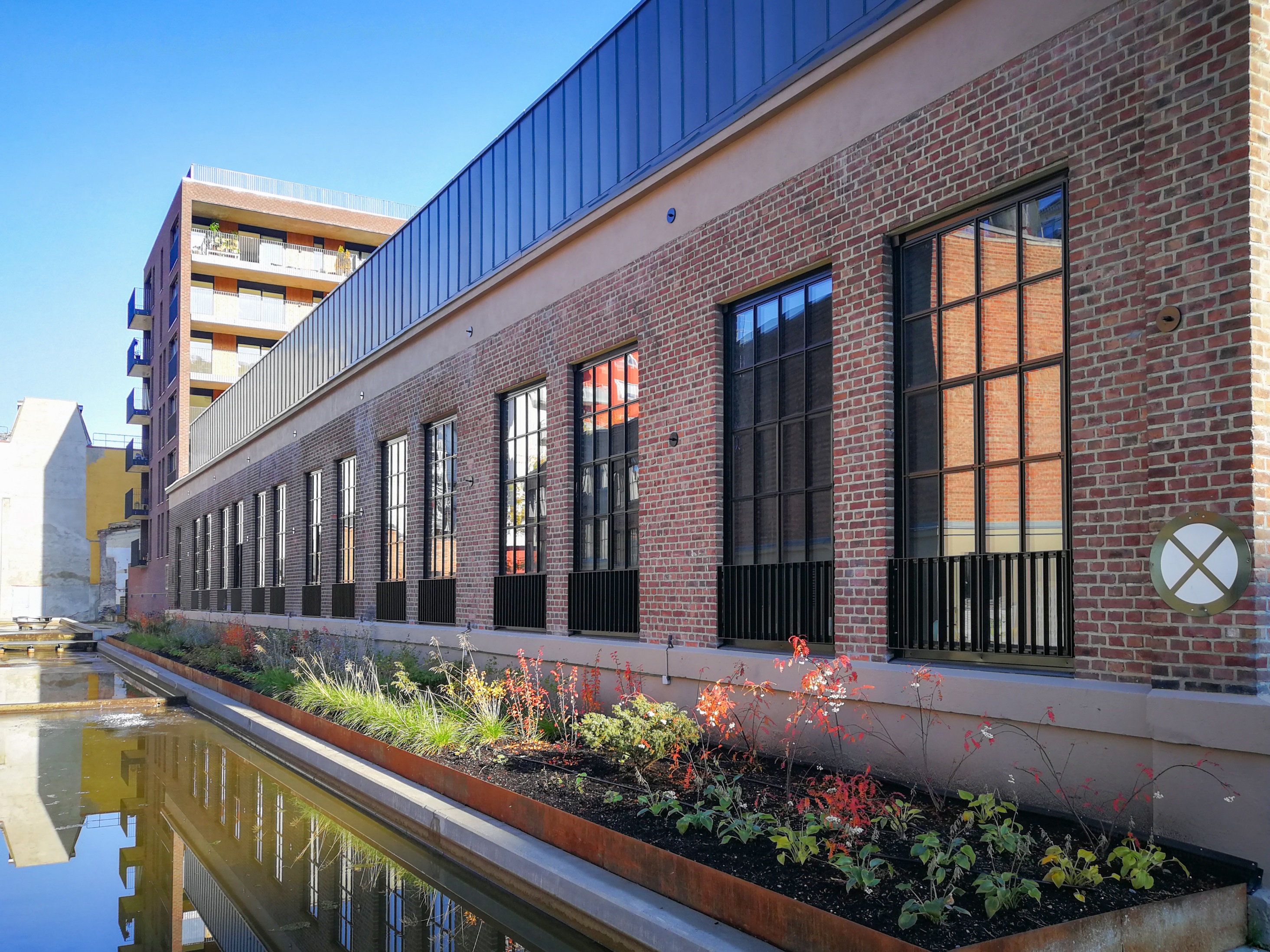 Tall slim-profile aluminium windows in a renovated brick building in Denmark